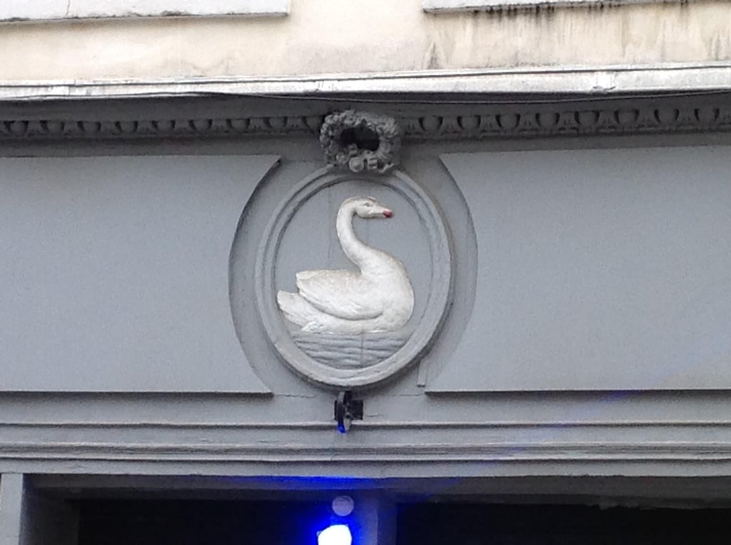 a red street sign hanging from the side of a building