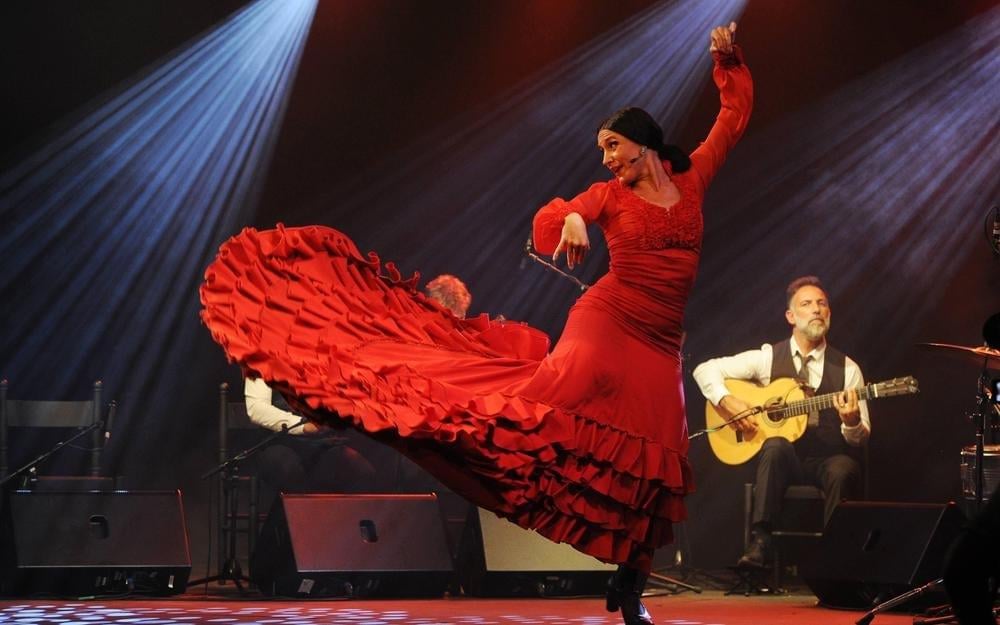 A couple dances tango with a live orchestra.