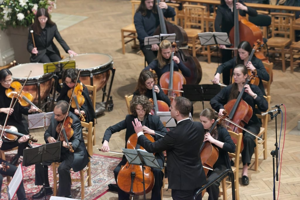 An orchestra is performing on a concert stage.