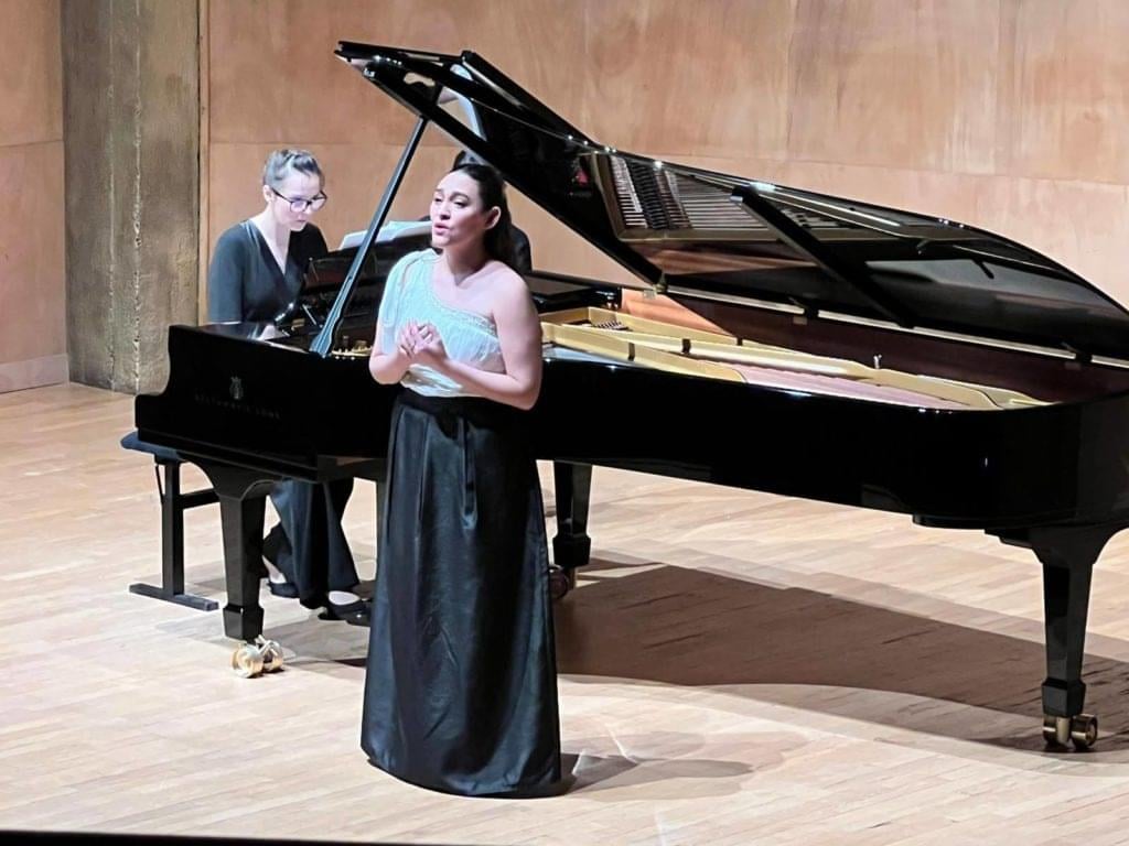 A man in a tuxedo playing a piano