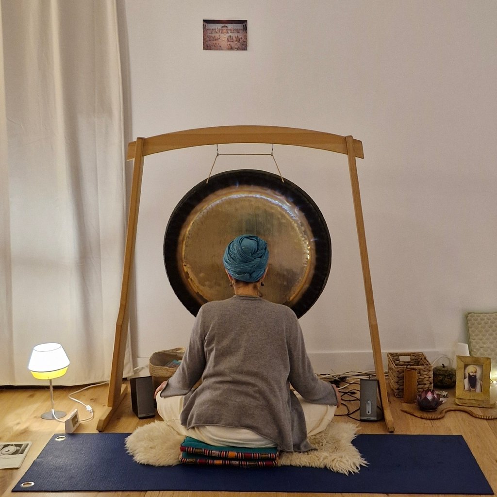 Sportsman handsome bearded man is recording video for internet vlog doing yoga talking in modern studio waving hand using smartphone camera on tripod.