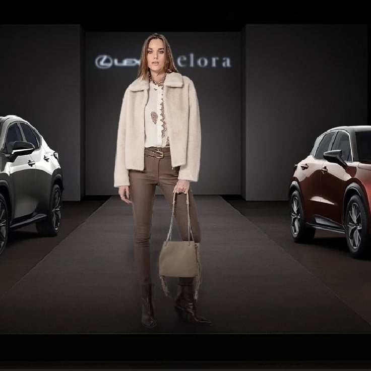 green car parked beside white brick wall