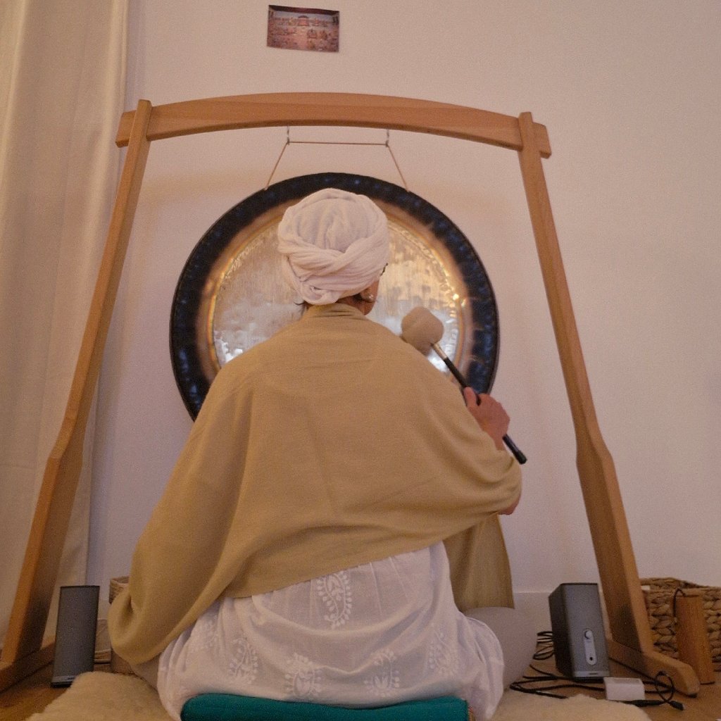 Sportsman handsome bearded man is recording video for internet vlog doing yoga talking in modern studio waving hand using smartphone camera on tripod.