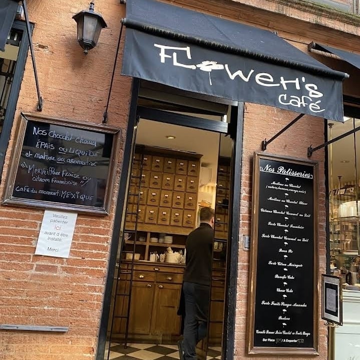 a pink flower in a pot next to a burger king sign
