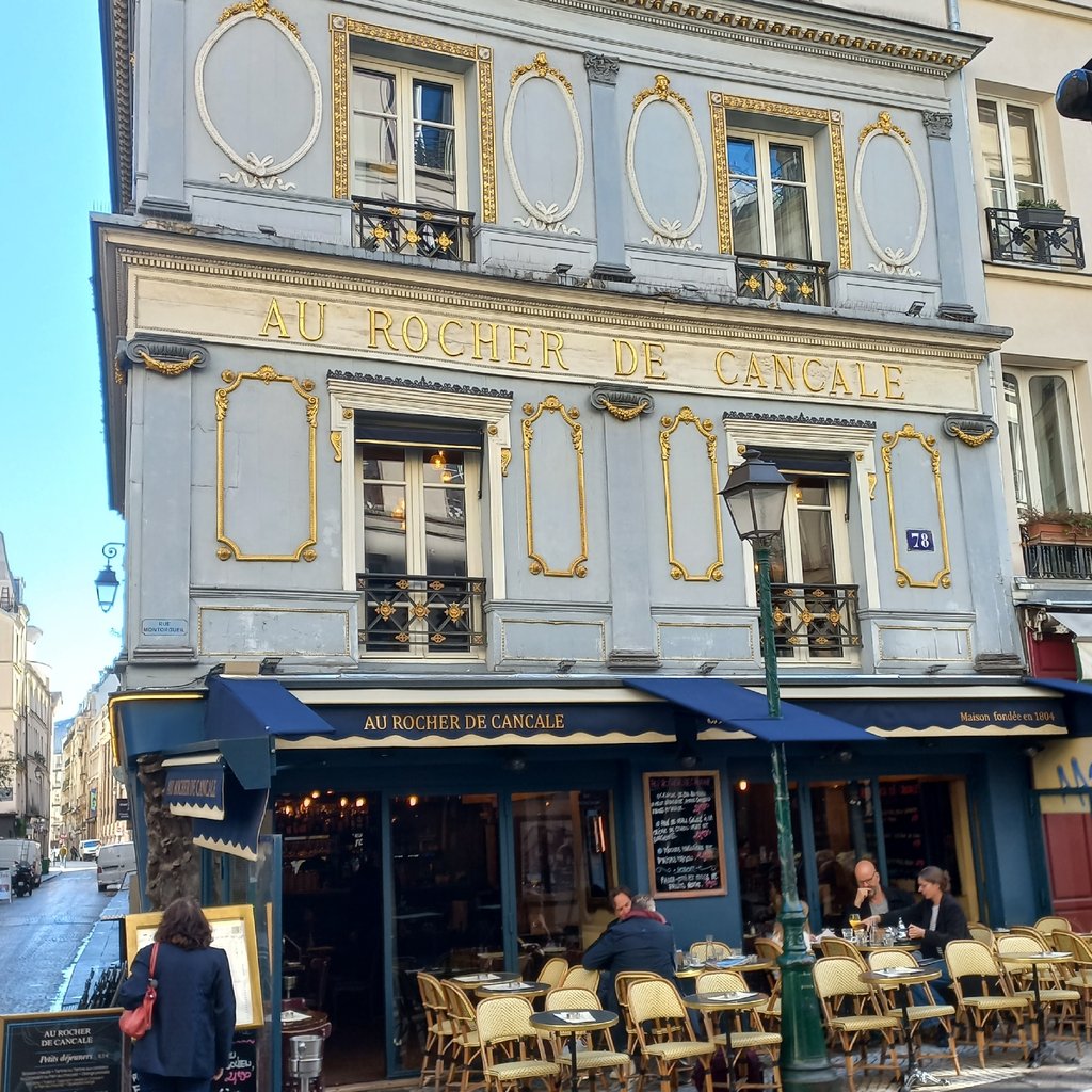 people sitting on chair near red building during daytime