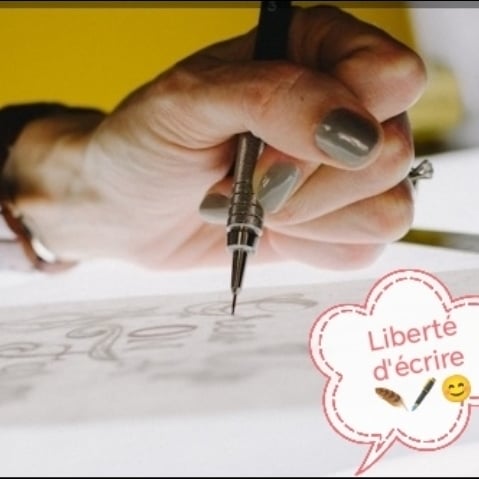 a woman sitting at a table painting a picture