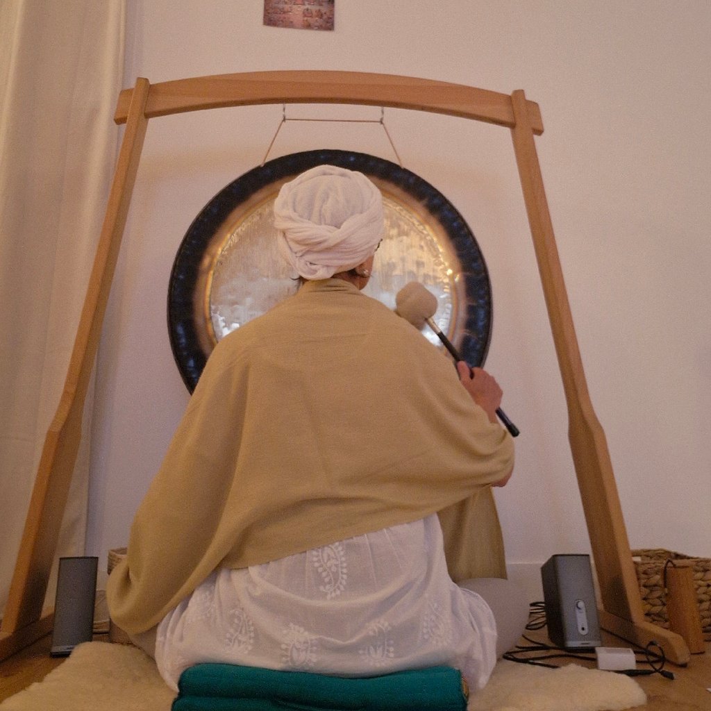 Sportsman handsome bearded man is recording video for internet vlog doing yoga talking in modern studio waving hand using smartphone camera on tripod.