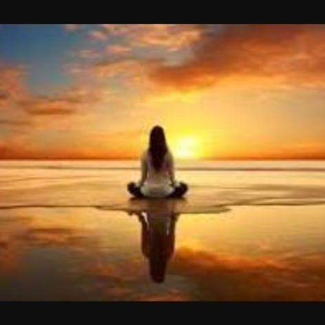 Male yoga teacher vlogger is recording tutorial using smartphone camera in modern studio stretching arms talking sitting on mat. Vlogging and sports concept.