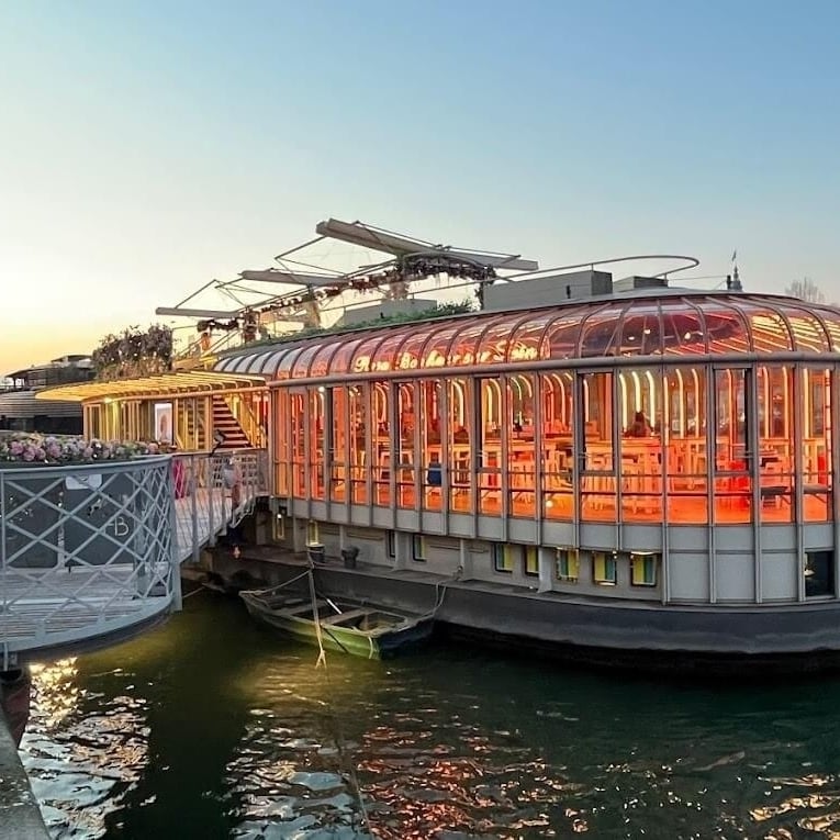 A red and pink photo of a rusted out car