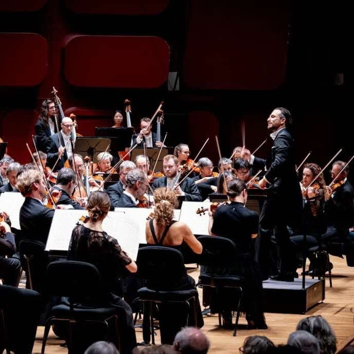 Group of people performing on stage with microphones.