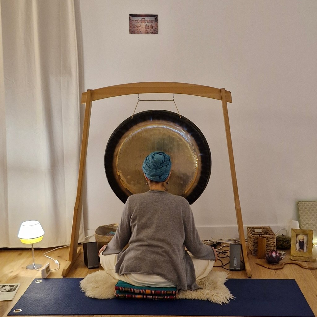 Sportsman handsome bearded man is recording video for internet vlog doing yoga talking in modern studio waving hand using smartphone camera on tripod.