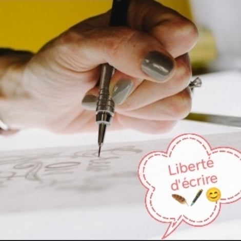 a woman sitting at a table painting a picture