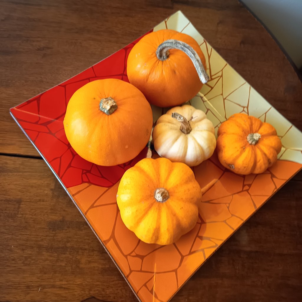 a table topped with candles and pumpkins next to a window