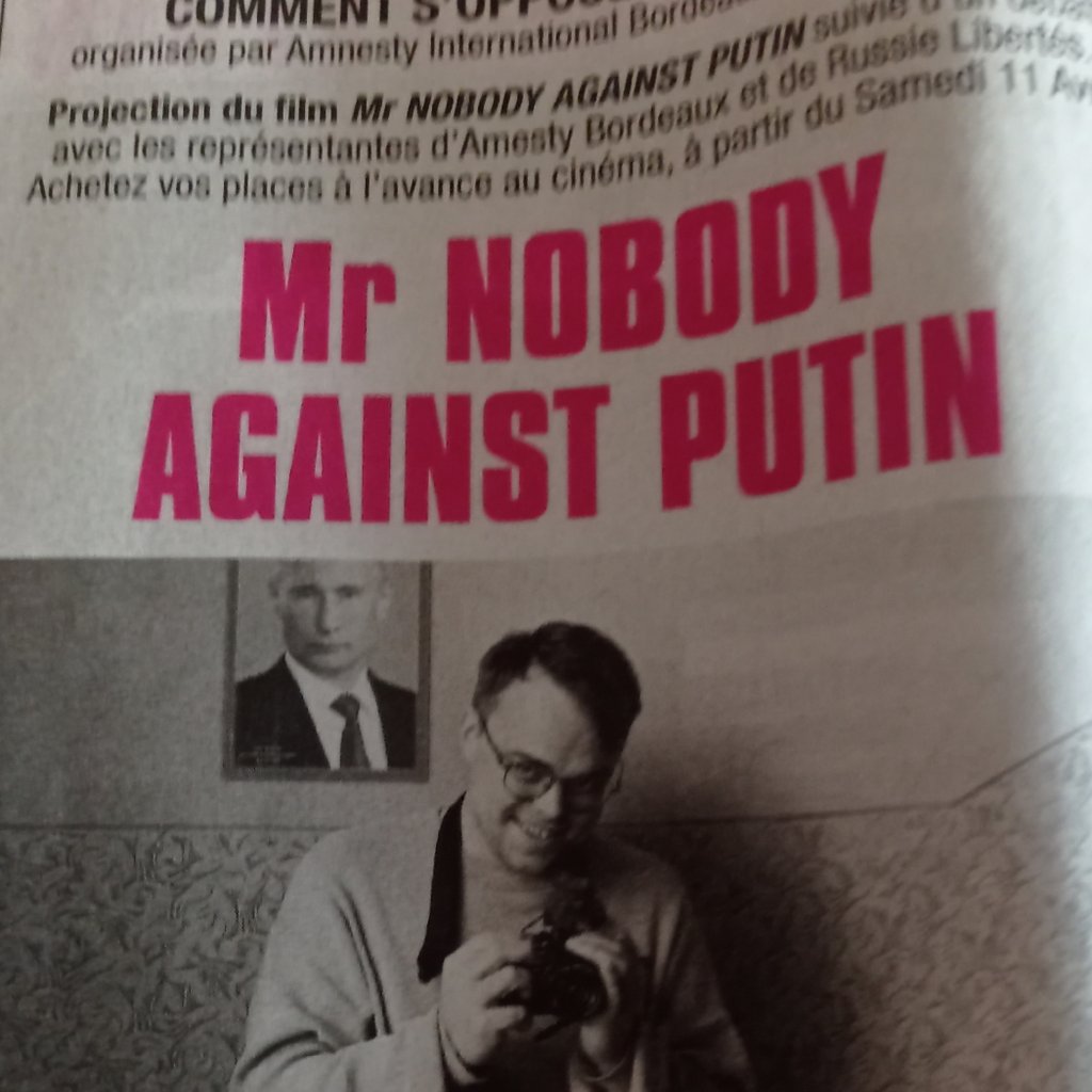 a person holding a sign with a picture of a man's face on it