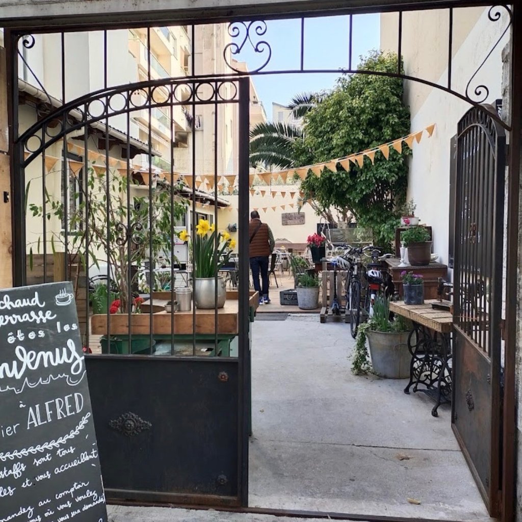 the outside of a restaurant with tables and chairs